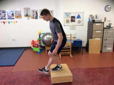 Boy pistol squatting on block exercise