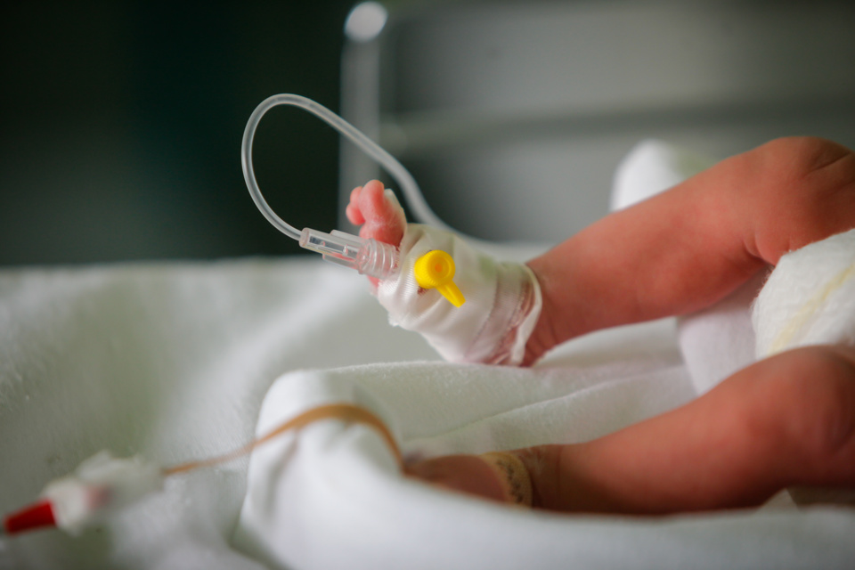 Tubing attached to new-borns foot in incubator