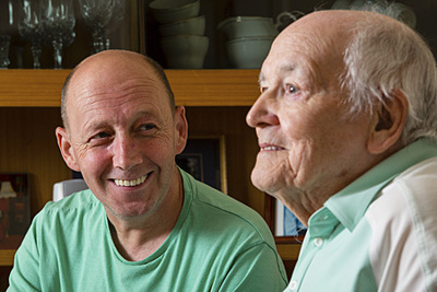 Man smiling looking at older man