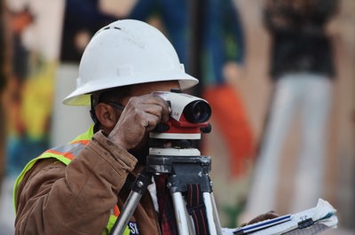 construction worker looking through surveying camera