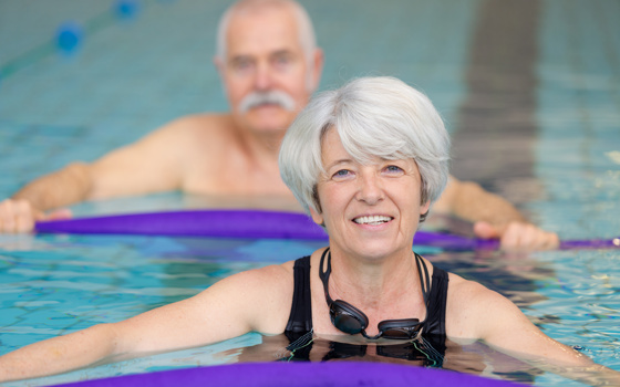 Older Adult Swimming with pool noodle