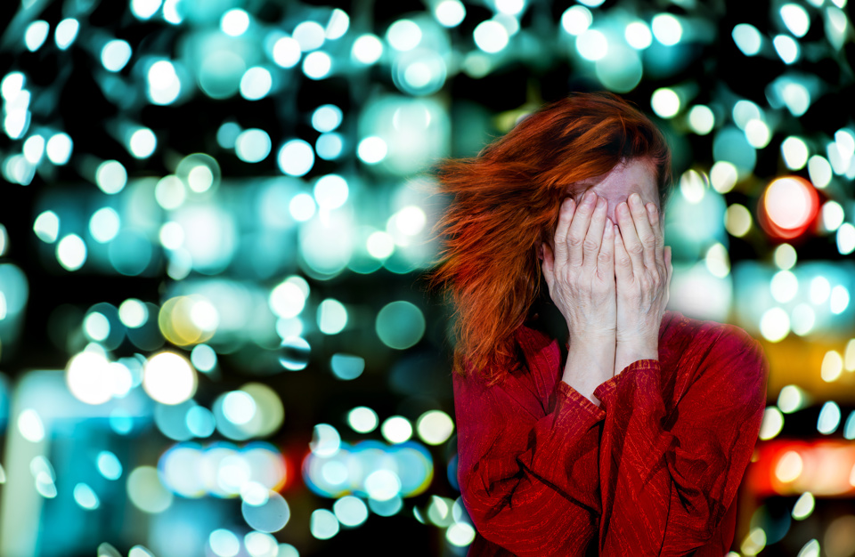 Woman covering eyes to avoid flashing lights